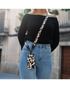 Vrouw draagt Mio Leopard telefoonhoesje met bijpassende strap over de schouder.